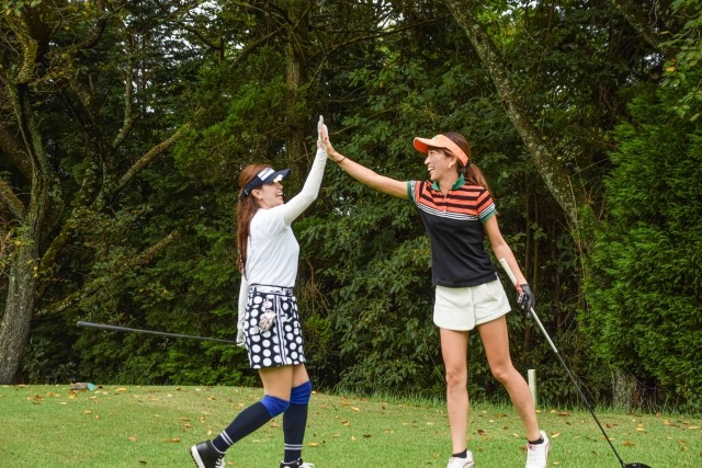 ゴルフ場でハイタッチをする女性たち